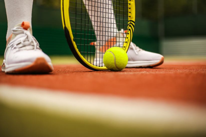 Una raqueta de tenis y una pelota.